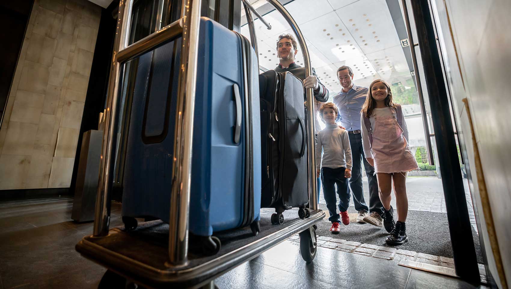 Family entering hotel with bellman
